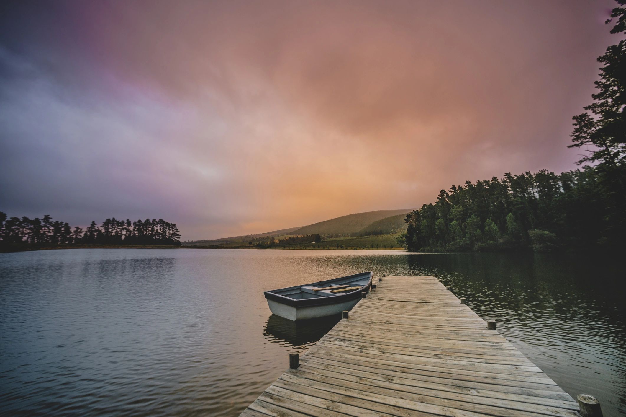 Boat docked on a calm lake at sunrise